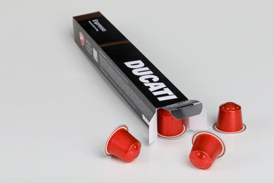 Open Espresso by Ducati box with red capsules for Nespresso® Original spilling out